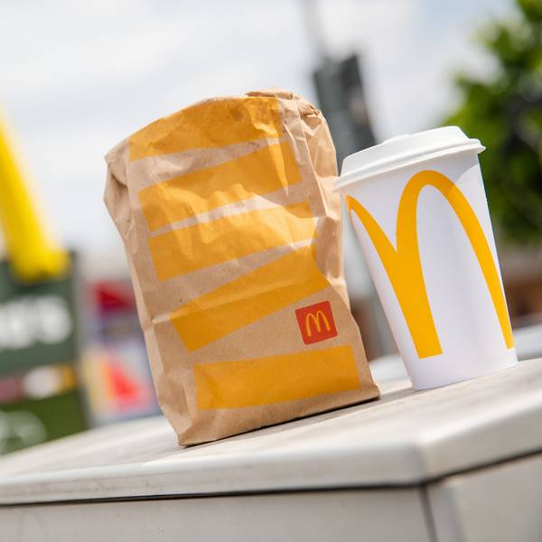 Eine McDonald's To-Go-Tüte und ein To-Go-Becher stehen vor einer Tübinger McDonald's-Filiale.