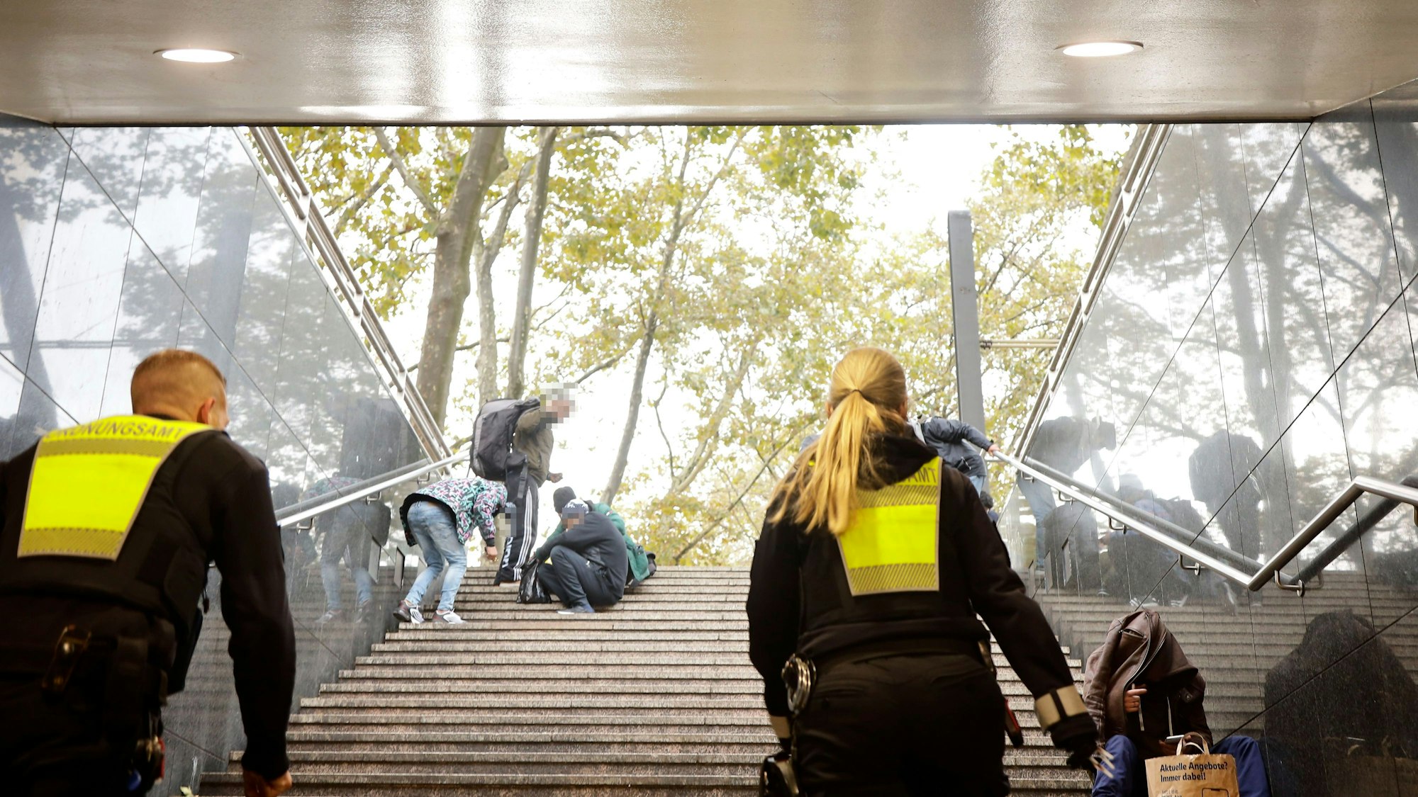 Riha und Mader gehen die Treppen am Neumarkt hoch, dort sitzen Drogensüchtige.
