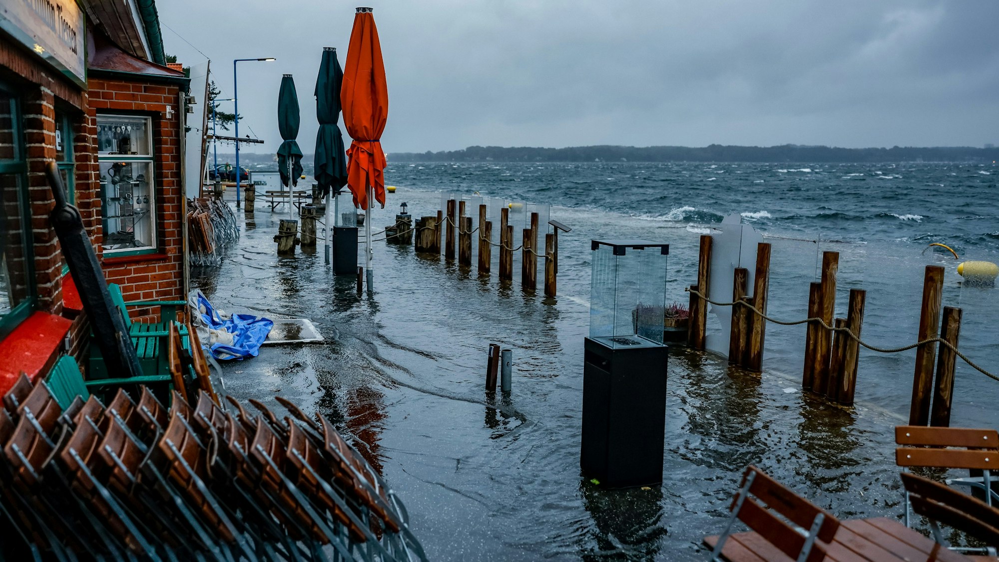 Die Straße vor den Cafes und Geschäften am Tiessenkai im Kiler Stadteil Holtenau ist vollständig von der Ostssee überflutet.