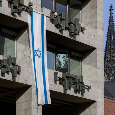 Eine israelische Flagge hängt an der Fassade des Kölner Rathauses.