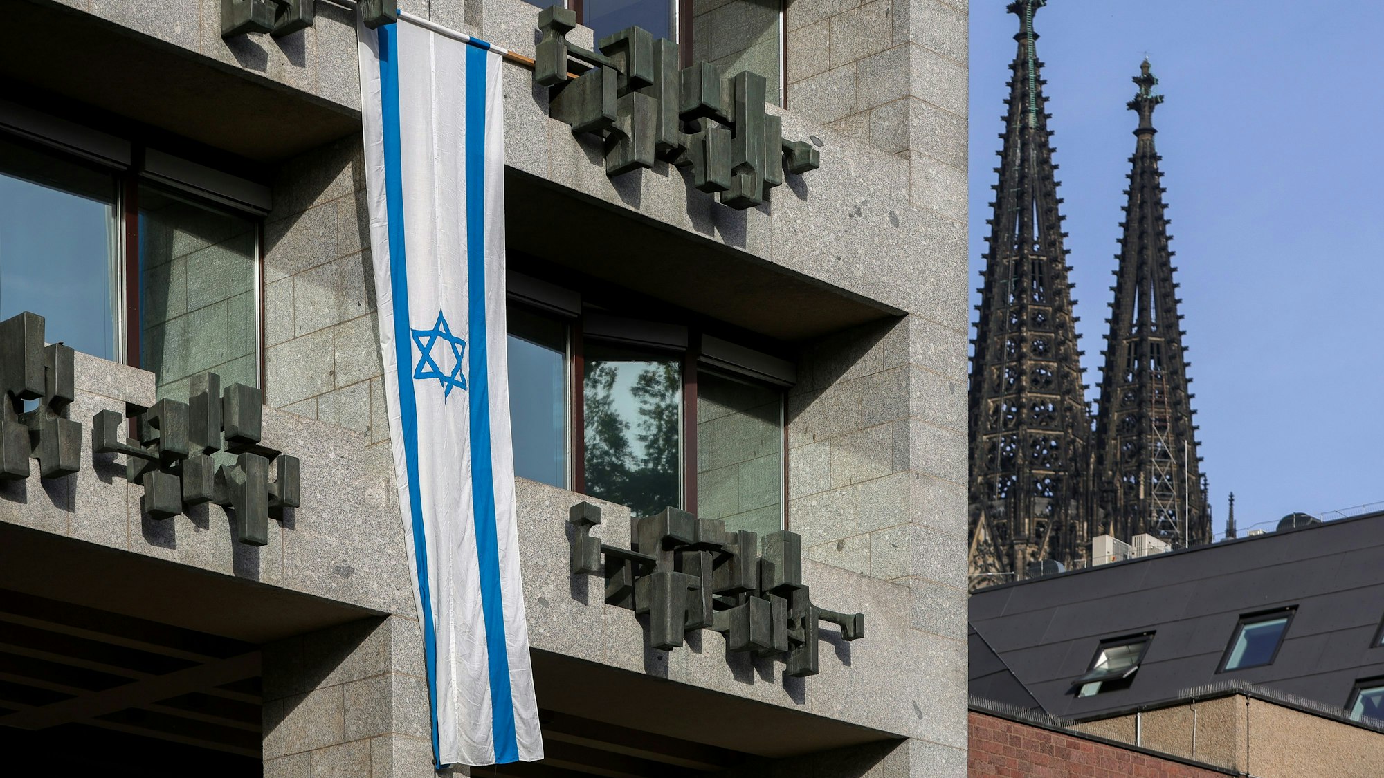 Eine israelische Flagge hängt an der Fassade des Kölner Rathauses.