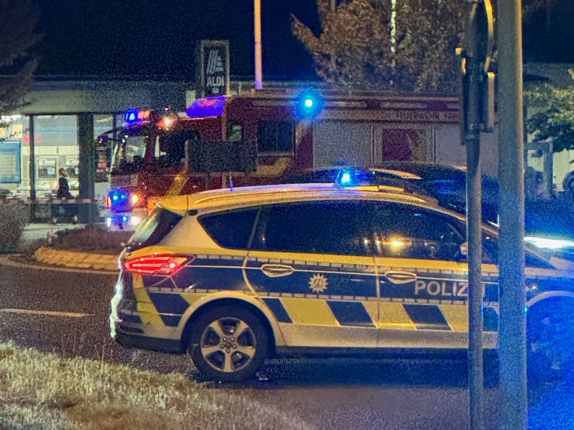 Das Bild zeigt eine Straße, die durch einen Streifenwagen abgesperrt ist.
