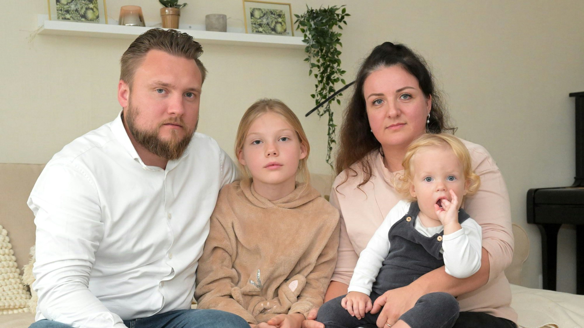 Familie Geperle sitzt auf der Couch in ihrem Haus.