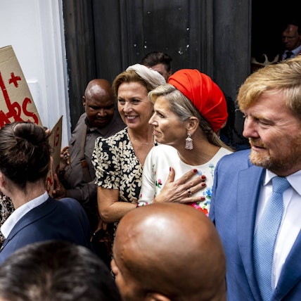 Königin Máxima und König Willelm-Alexander werden von Demonstranten bedrängt.