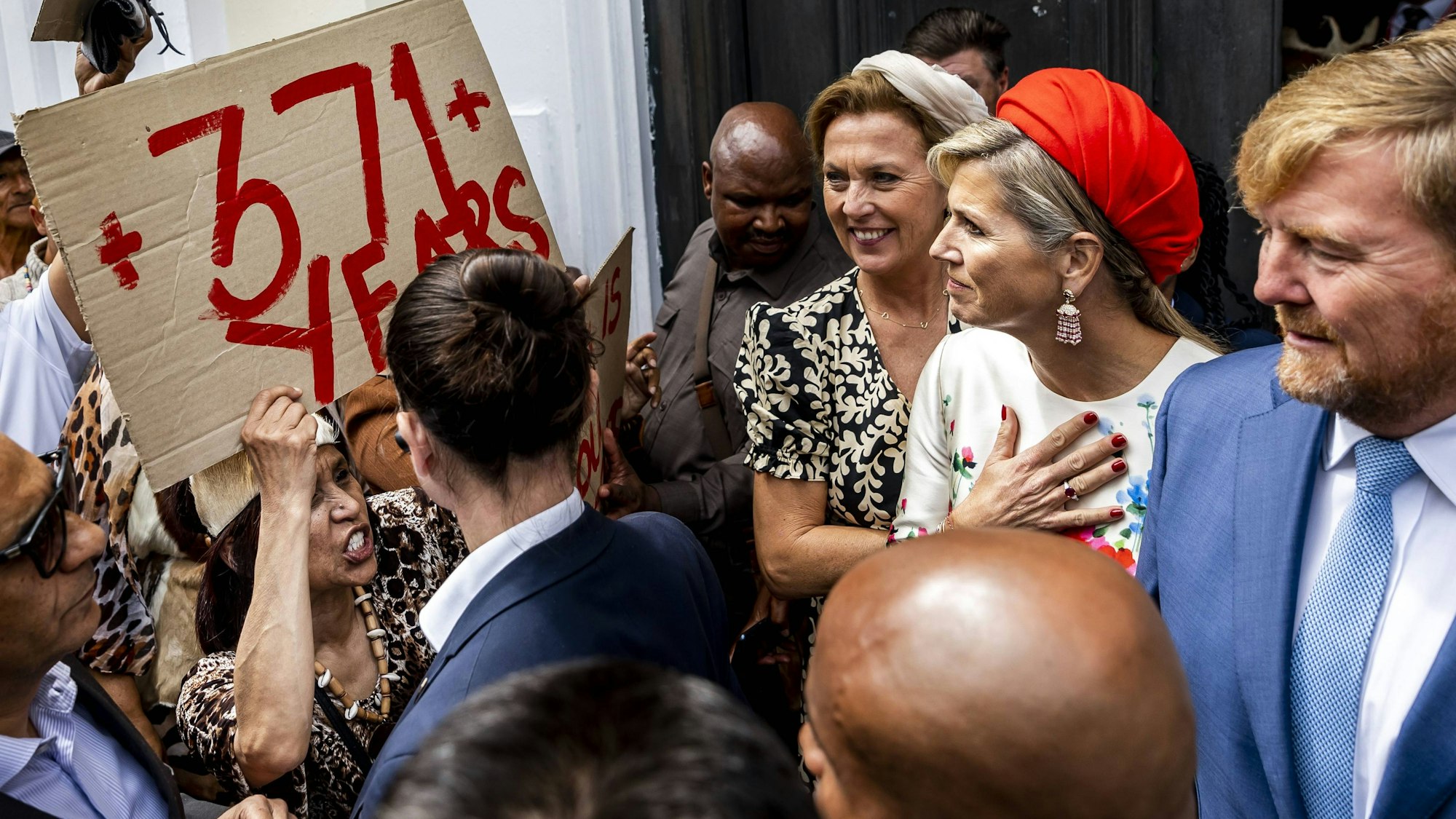 Königin Máxima und König Willelm-Alexander werden von Demonstranten bedrängt.