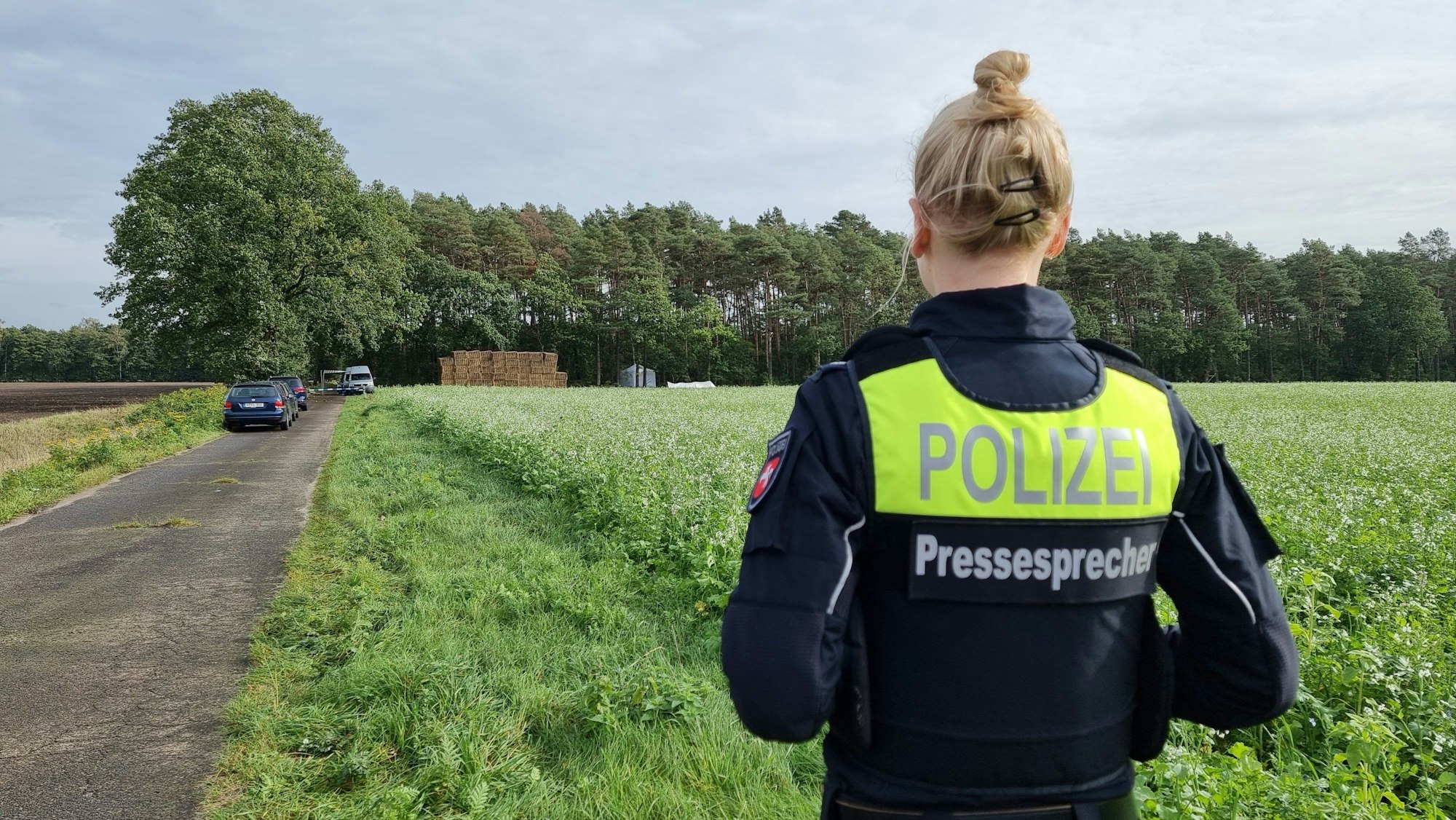 Eine Polizistin steht vor einem Wald bei Fuhrberg in der Region Hannover. Bei den von Pilzsammlern gefundenen menschlichen Knochen in einem Wald nahe Burgwedel handelt es sich um den Leichnam der 56 Jahre alten Frau, die im September 2022 in ihrer Laube am Würmsee erstochen wurde. In dem Gerichtsprozess zum Würmsee-Mord hatten zahlreiche Indizien wie Blut- und DNA-Spuren dem Gericht zufolge den 55 Jahre alten Familienvater als Täter überführt.