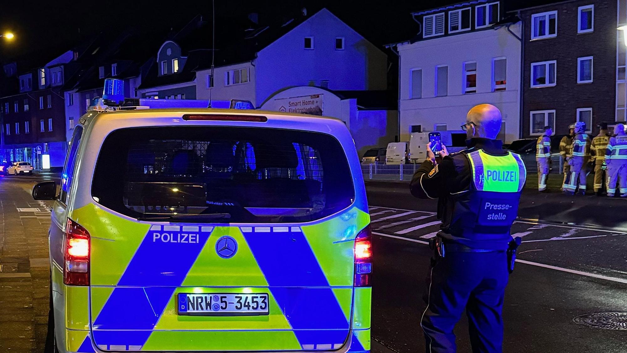 Das Bild zeigt einen Polizeibeamten an einem Streifenwagen.