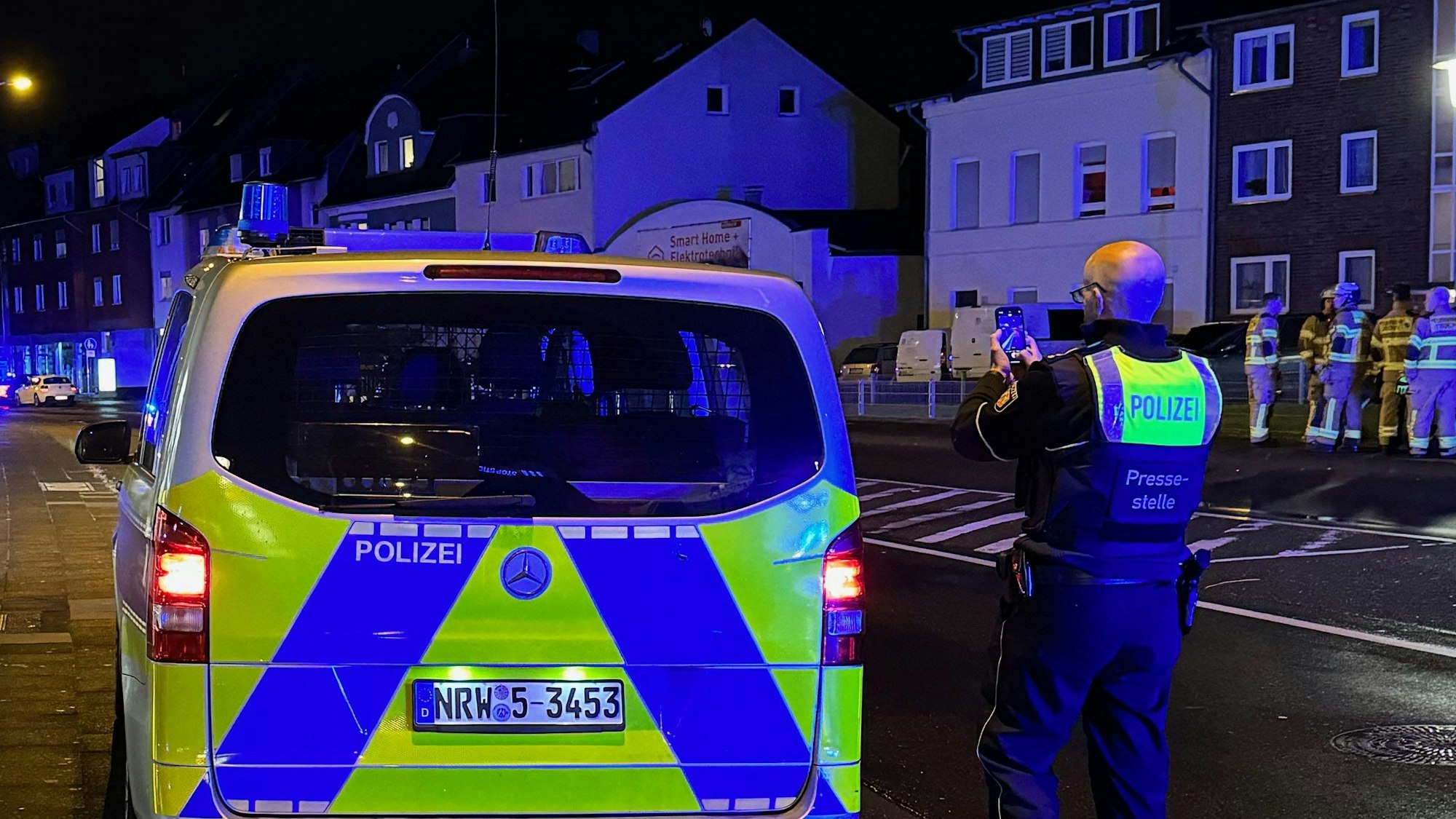Das Bild zeigt einen Polizeibeamten an einem Streifenwagen.
