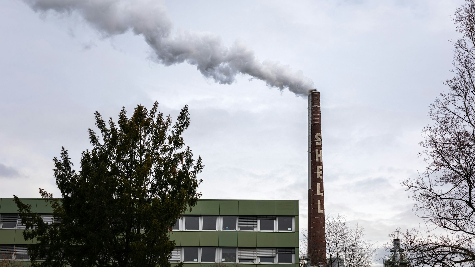 Dampf, Qualm und Rauch kommen aus einem Schornstein auf dem Gelände der Shell Rheinland Raffinerie.