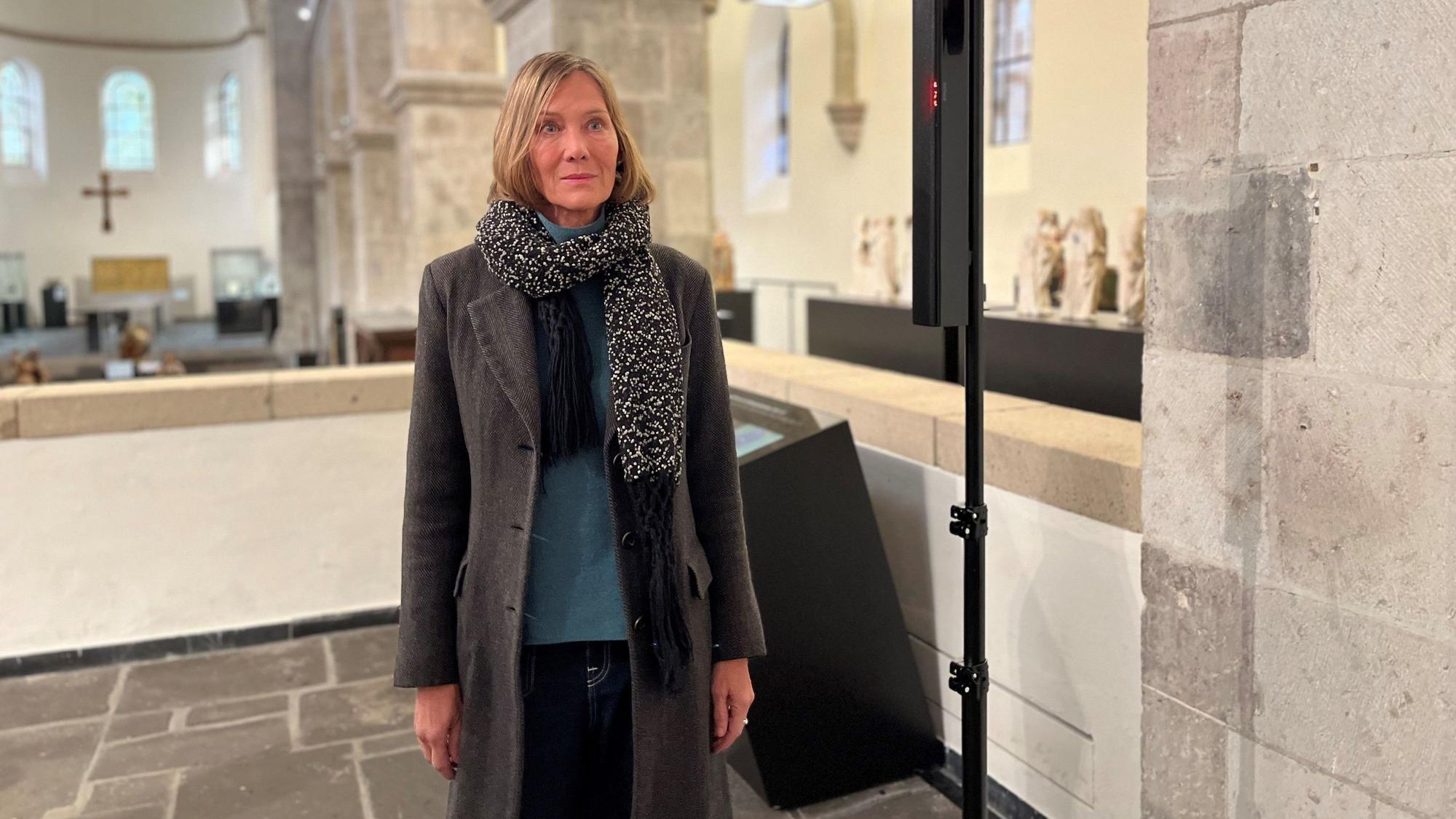 Die Künstlerin Franka Hörnschemeyer steht im Museum Schnüttgen. Sie trägt einen Wintermantel mit Strickschal.