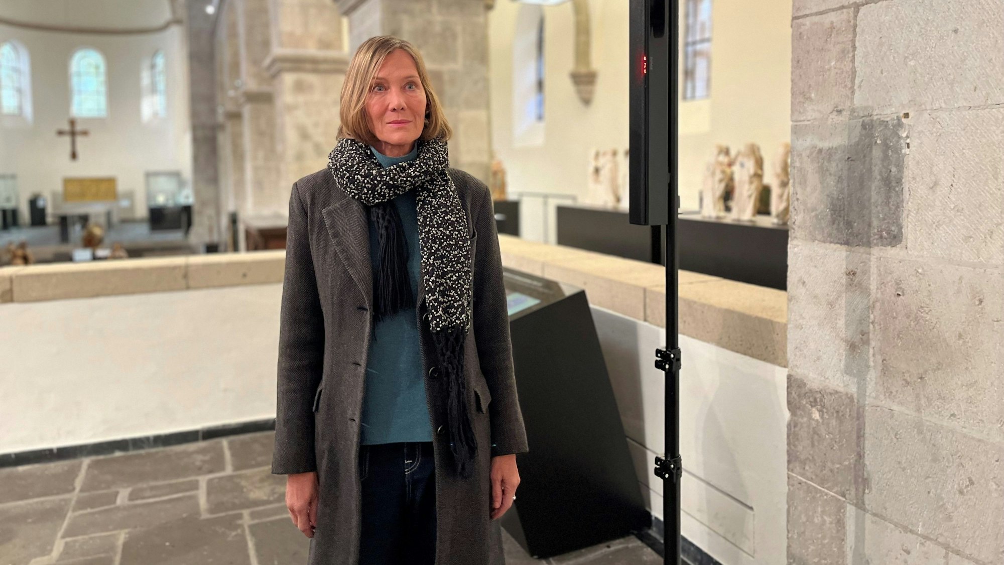 Die Künstlerin Franka Hörnschemeyer steht im Museum Schnüttgen. Sie trägt einen Wintermantel mit Strickschal.