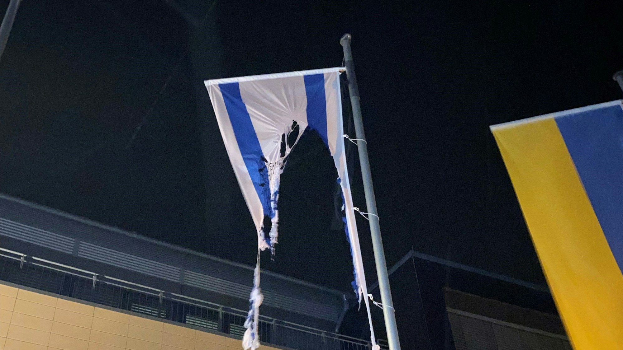 Vor dem Mechernicher Rathaus hängen Reste einer israelischen Flagge, die Unbekannte in der Nacht zum 20. Oktober in Brand gesetzt haben.