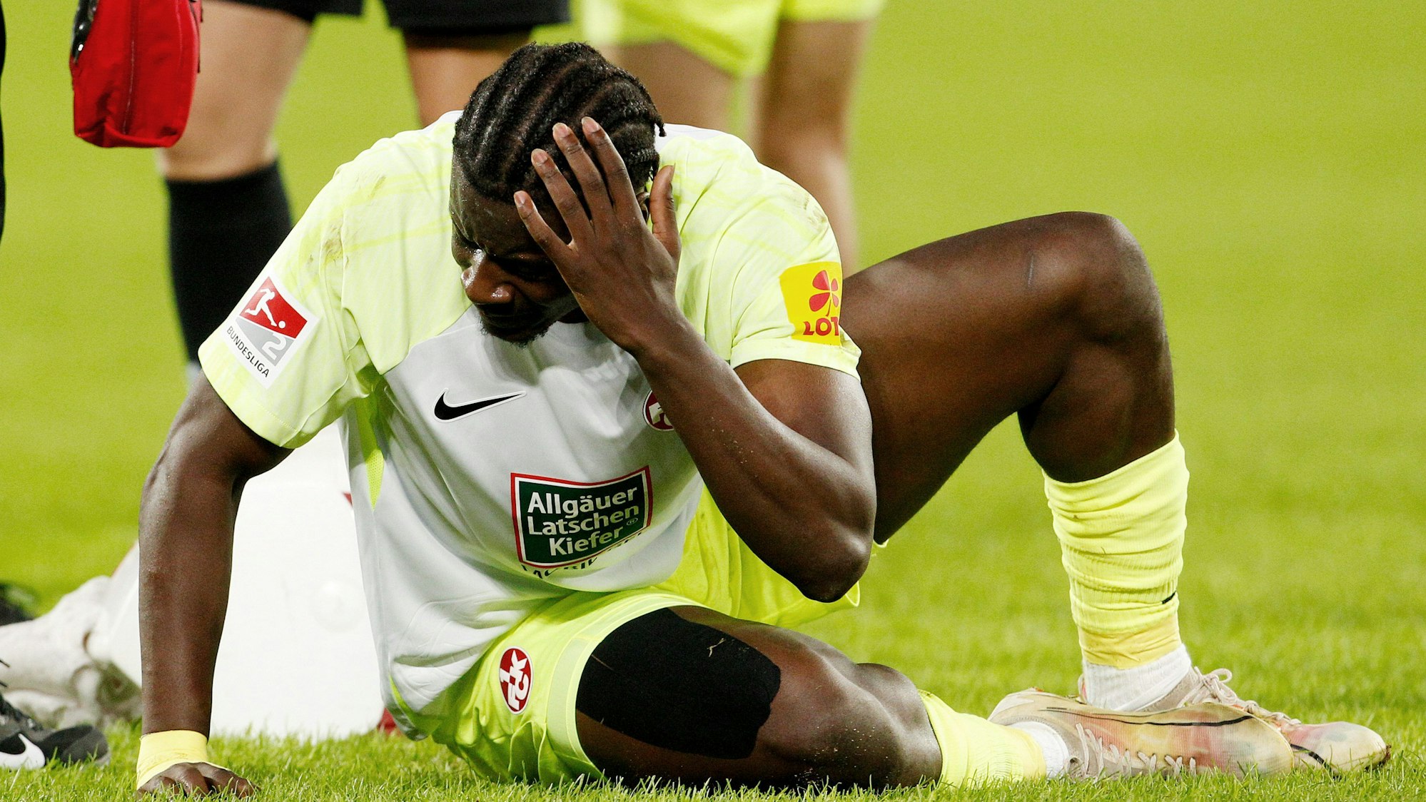 Der Kaiserslauterer Ragnar Prince Friedel Ache fasst sich an den Kopf nachdem er von einem geworfenen Gegenstand am Kopf getroffen wurde.