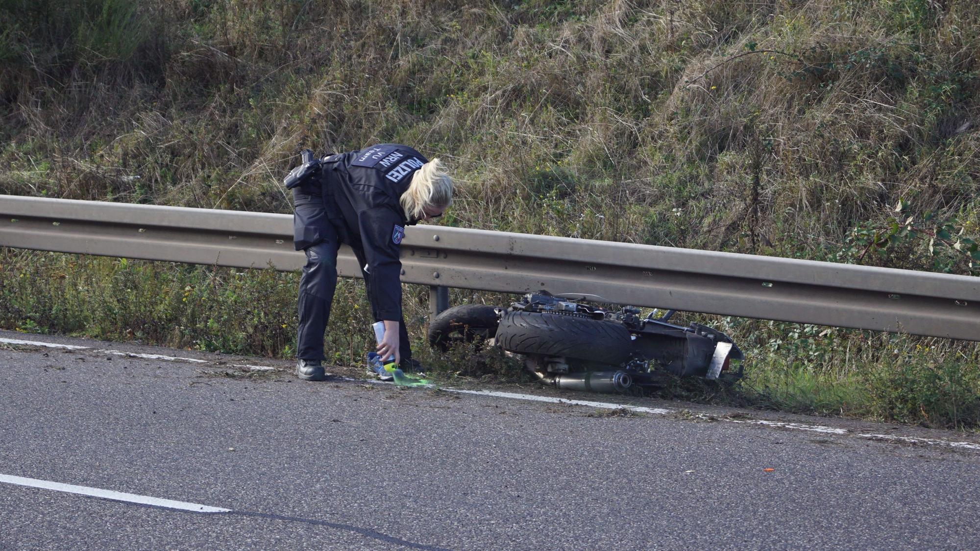 Das Bild vom Oktober 2023 zeigt eine Polizistin, die nach einem tödlichen Unfall auf der B266 eine Stelle an einem Motorrad mit Sprühfarbe markiert.