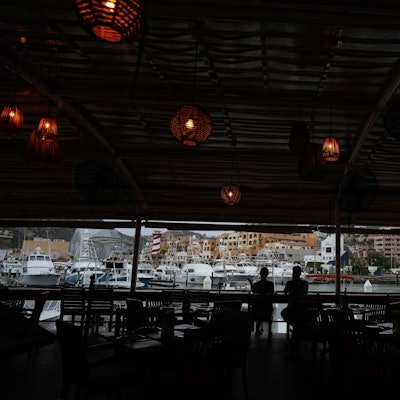 Ein Touristenpaar nimmt einen Drink in einer noch geöffneten Bar am Hafen von Cabo San Lucas.