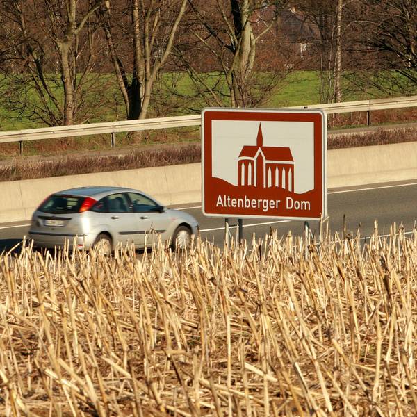Ein Auto fährt auf der A1 an einem touristischen Hinweisschild für den Altenberger Dom vorbei,