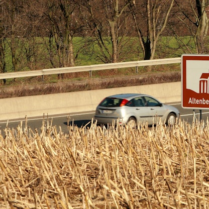 Ein Auto fährt auf der A1 an einem touristischen Hinweisschild für den Altenberger Dom vorbei,
