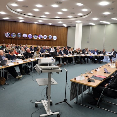 Im großen Sitzungssaal des Kreishauses Amt Rübezahlwald sitzen die Kreistagsmitglieder und die Verwaltung an Tischen.