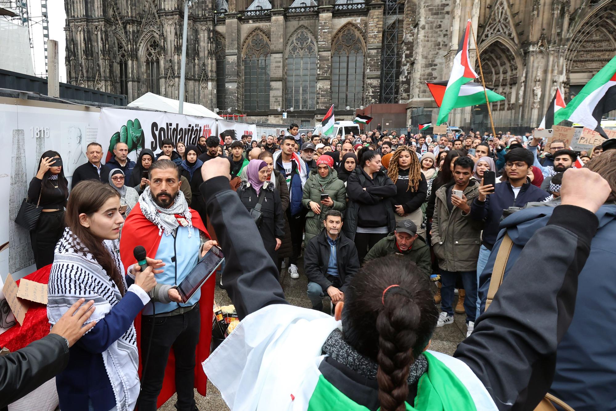Ein junges Mädchen mit Palästinensertuch spricht auf der Demo in ein Mikrofon.