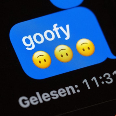 Im Display eines Smartphones ist in einem Chat-Verlauf das Wort „goofy“ zu lesen