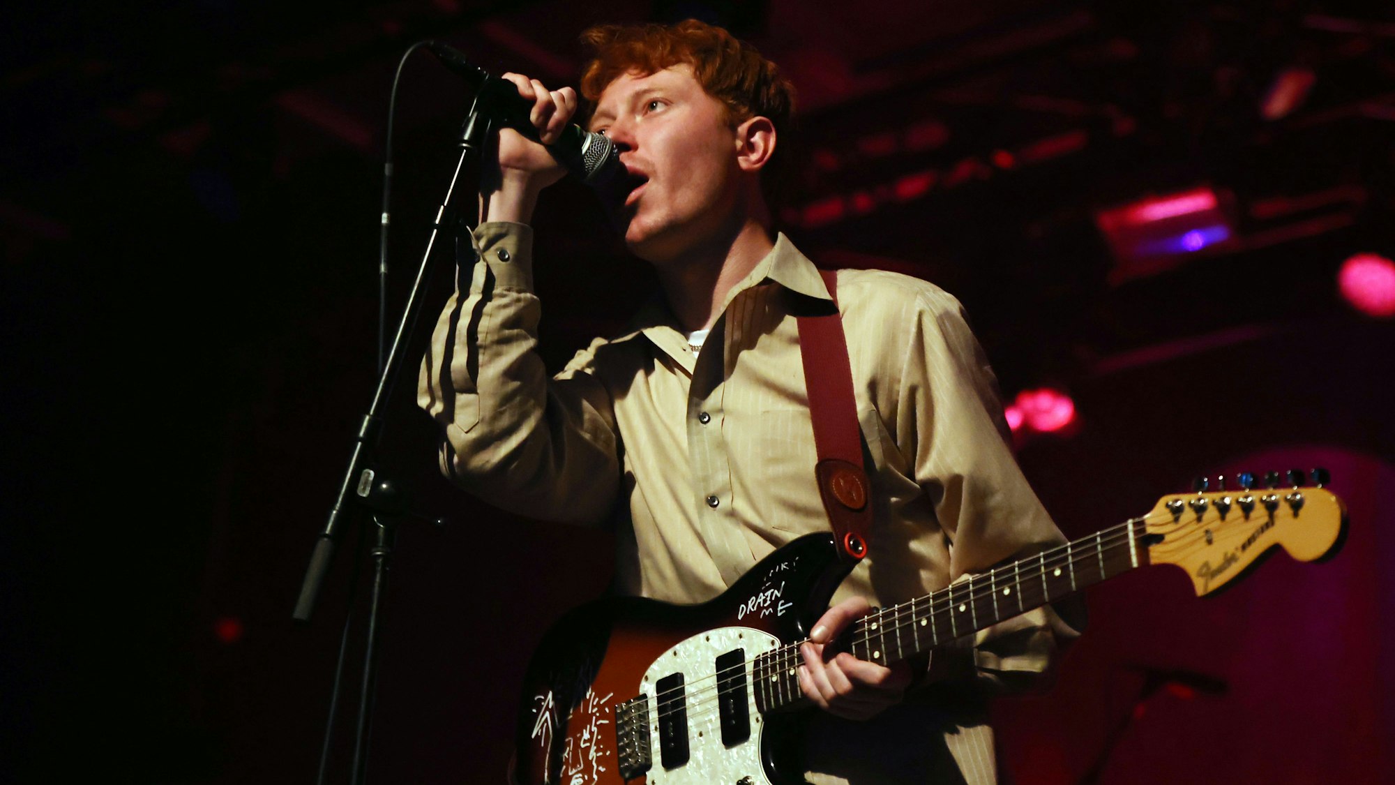 21.10.2023
Köln:
Konzert King Krule im Carlswerk Victoria, Sänger und Gitarrist Archy Marshall klammert sich ans Standmikrofon. Er trägt ein grün-beiges Hemd.