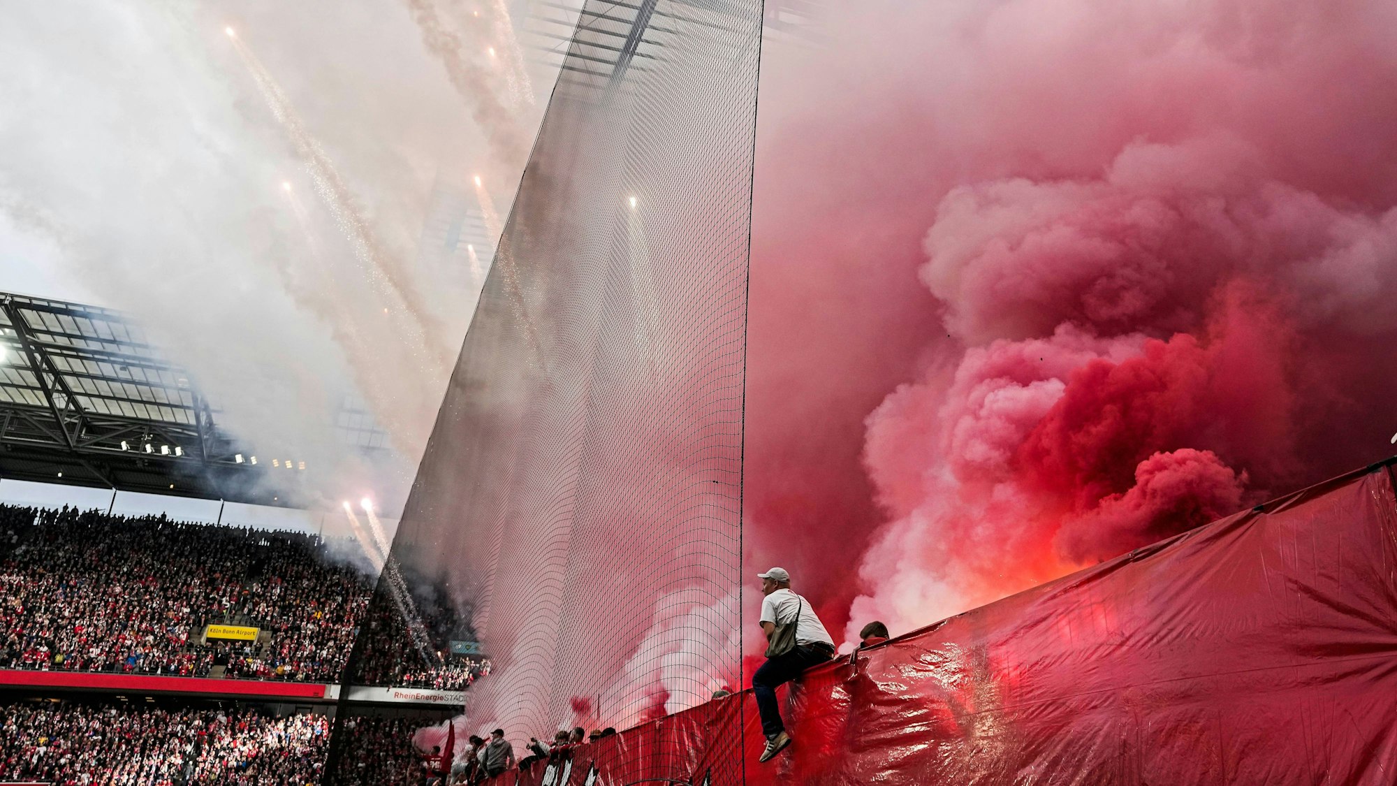 Plötzlich fliegen Feuerwerkskörper durch das Rhein-Energie-Stadion in Köln.