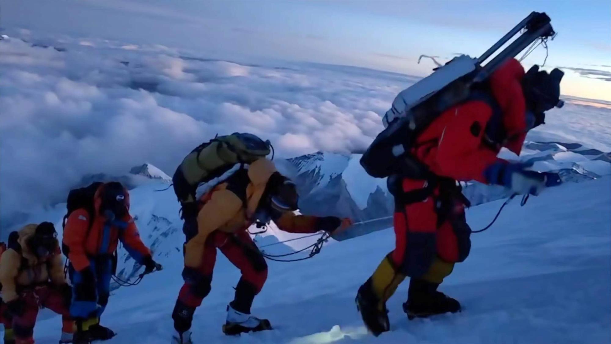 ARCHIV - 01.10.2023, China, Berg Cho Oyu: Mitglieder eines chinesischen Expeditionsteams steigen in einer Seilschaft auf den Gipfel des Berg Cho Oyu, der auch als Qowowuyag bekannt ist, im Himalaya.