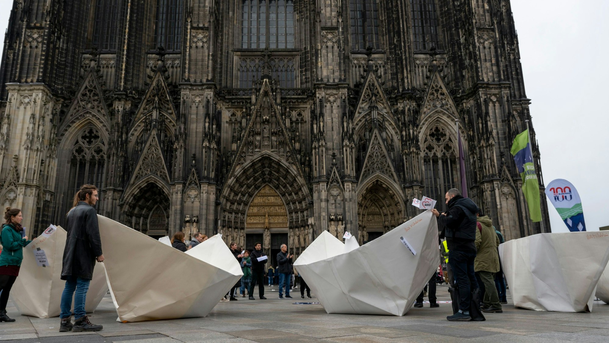 Überdimensionale Papierboote wurden vor dem Dom als Mahnmal für Menschen auf der Flucht ausgestellt.
„100 Boote – 100 Millionen Menschen” Der „Kreativhafen“ AWO Mittelrhein lädt ein zur Bootsübergabe am Kölner Dom.