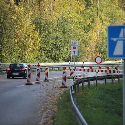 Zu sehen ist ein Auto, das an einer Straßensperrung vorbeifährt.
