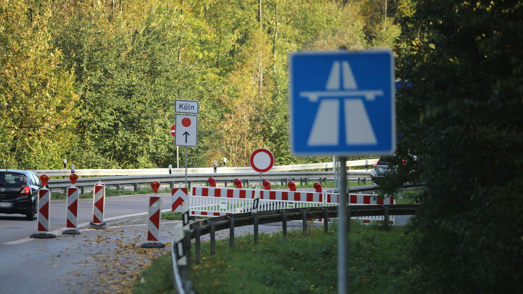 Zu sehen ist ein Auto, das an einer Straßensperrung vorbeifährt.