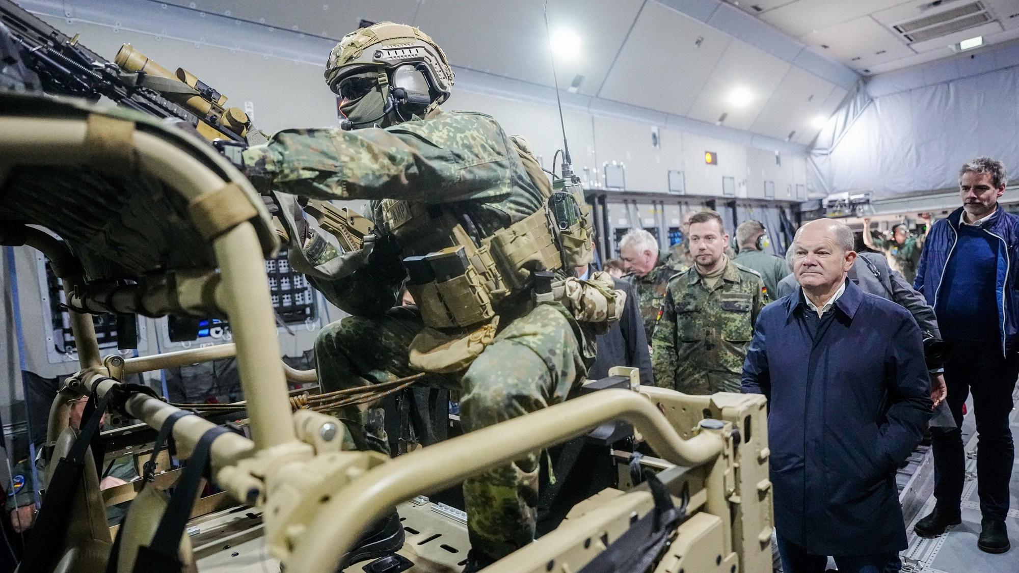 Bundeskanzler Olaf Scholz (SPD) wartet im Airbus A400M der Luftwaffe auf dem Militärflughafen Köln-Wahn hinter dem Air Mobile Protection Team auf den Ausstieg.