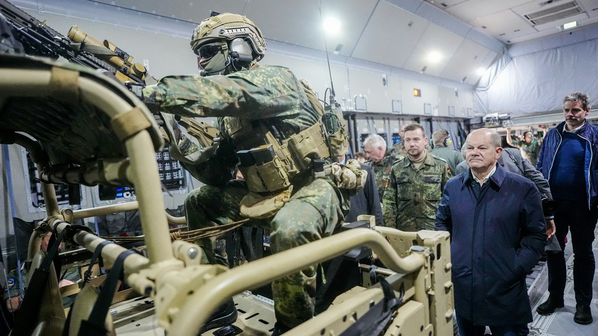 Bundeskanzler Olaf Scholz (SPD) wartet im Airbus A400M der Luftwaffe auf dem Militärflughafen Köln-Wahn hinter dem Air Mobile Protection Team auf den Ausstieg.
