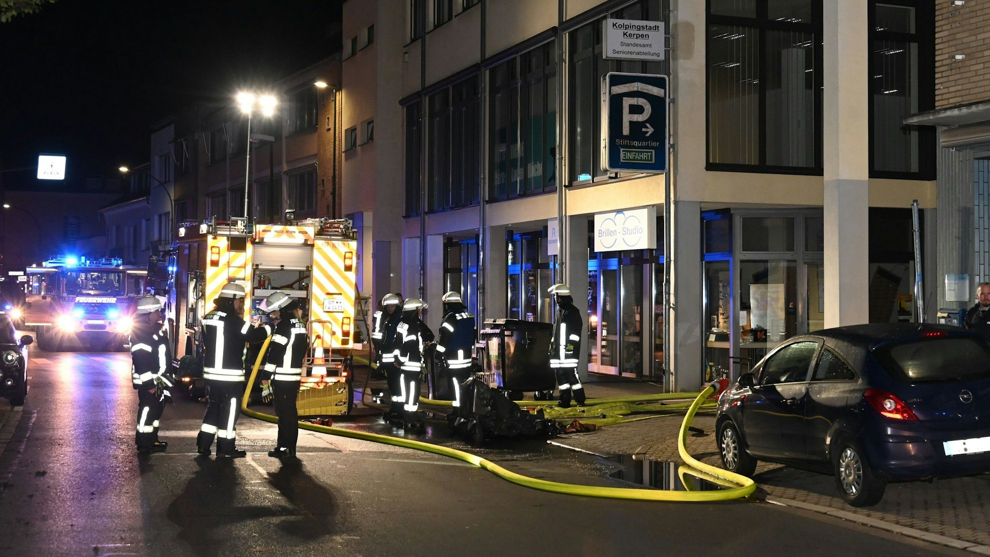 Auf dem Foto sind Feuerwehrleute vor dem Eingang zur Tiefgarage zu sehen.
