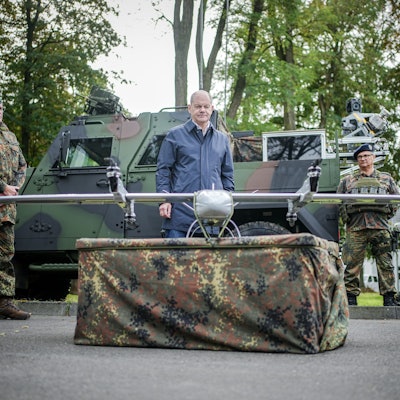 Bundeskanzler Olaf Scholz (SPD) schaut sich beim Besuch der Fähigkeitsdemonstration der Territorialen Verfügungsgruppe auf dem Militärflughafen Köln-Wahn eine Drohne an.