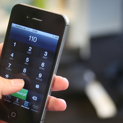 Das Bild zeigt eine Hand, die ein Smartphone festhält und die 110, die Notrufnummer der Polizei, eingetippt hat.