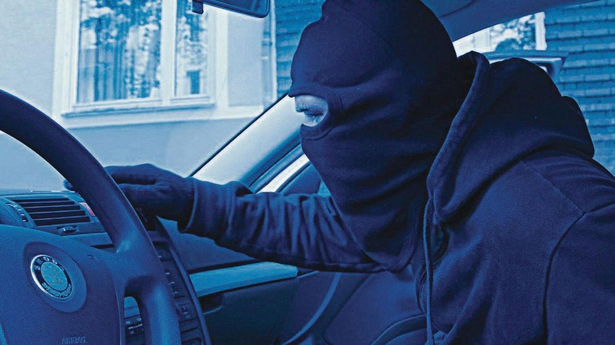 Ein Mann mit dunkler Maske in einem Auto