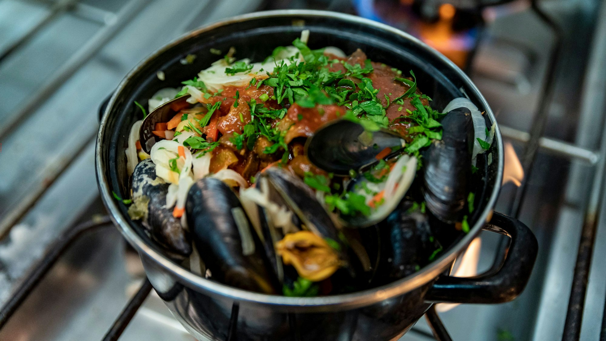 Muscheln stehen in einem Topf auf dem Herd.