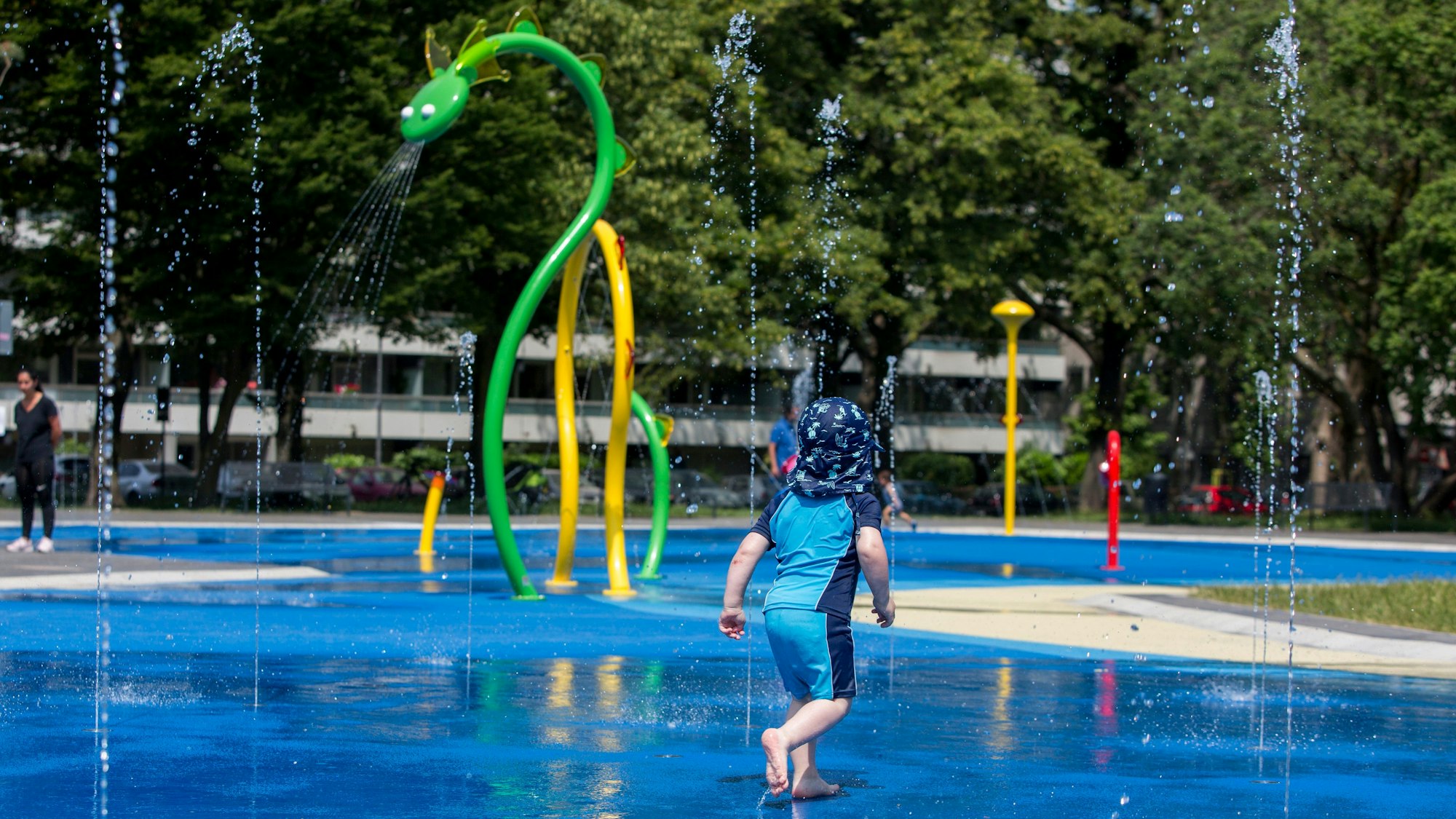 Ein Kind läuft über einen Spielplatz.