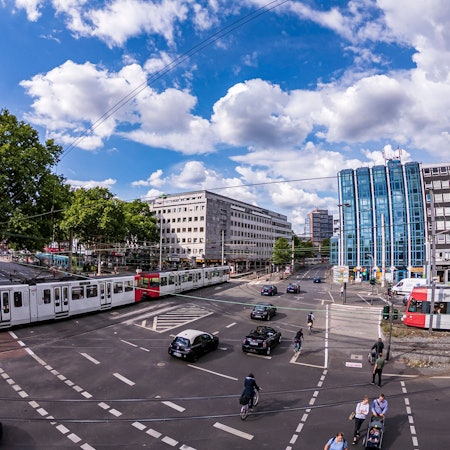 Blick über den Barbarossaplatz mit KVB-Bahnen und Autos.