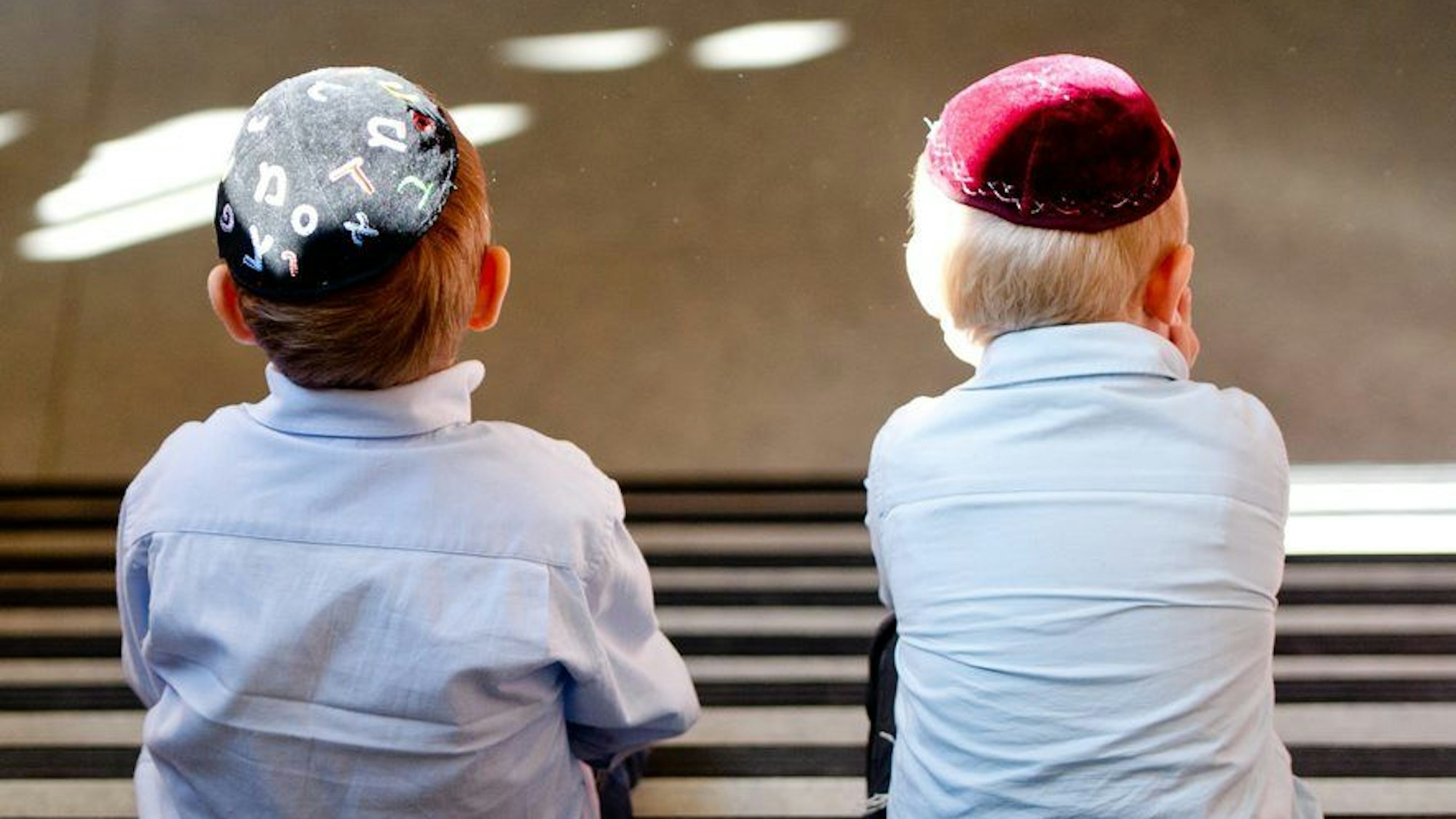 Zwei Jungen mit Kippa auf einer Treppe.