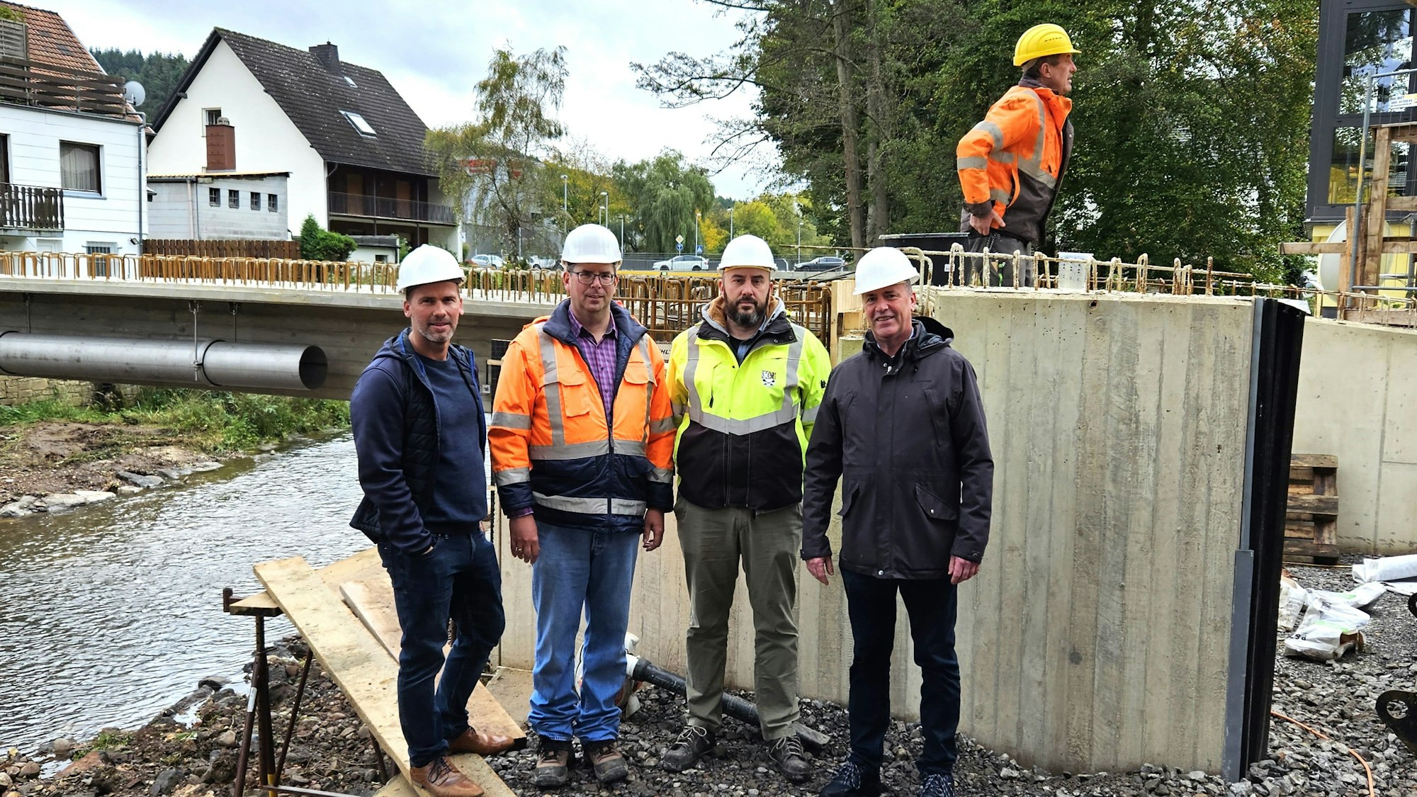 Vor der Brücke stehen (v.l.) Markus Auel (Vertreter des Bürgermeisters), Roman Schumacher, Christoph Graf (Bauamt) und Hermann-Josef Esser.