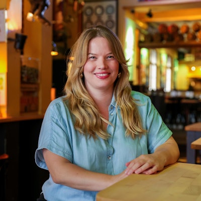 Lisa Dukowski steht lächelnd an einem Tisch im Hellers-Brauhaus.
