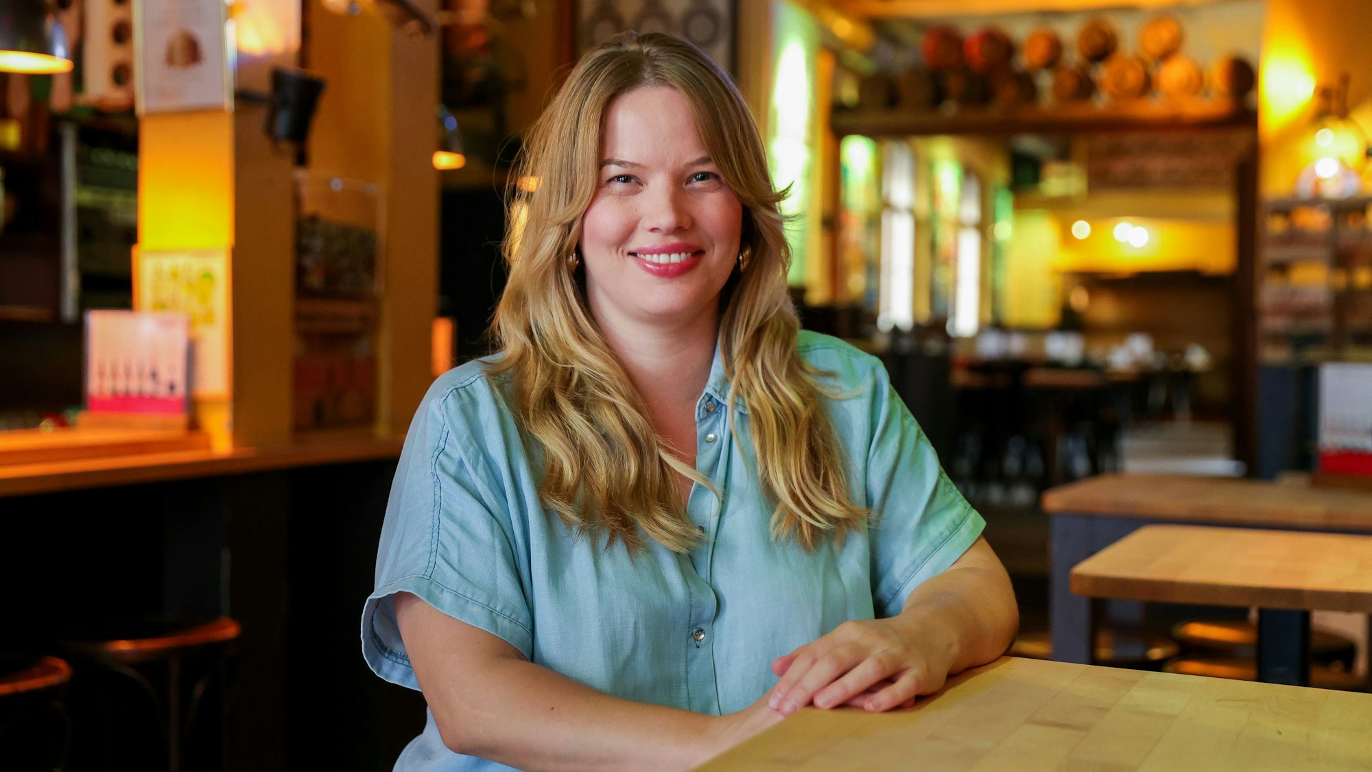 Lisa Dukowski steht lächelnd an einem Tisch im Hellers-Brauhaus.