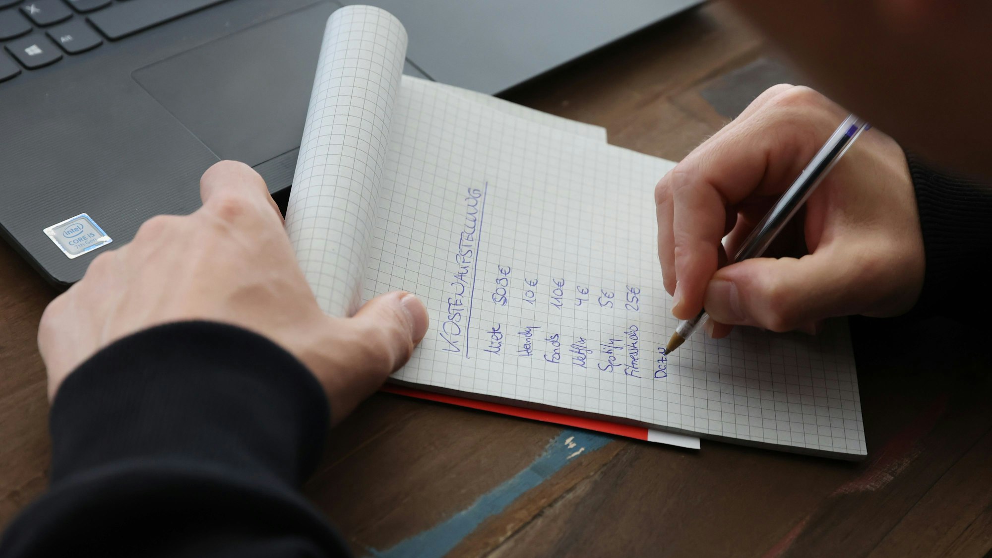 Student Jan-Phillip schreibt auf, was er monatlich einnimmt und ausgibt.