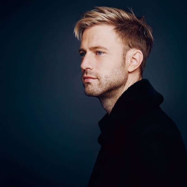 Appl ist auf dem Bild fast im Profil zu sehen, der Hintergrund ist udnkelblau. Er schaut verträumt , hat blondes Haar.