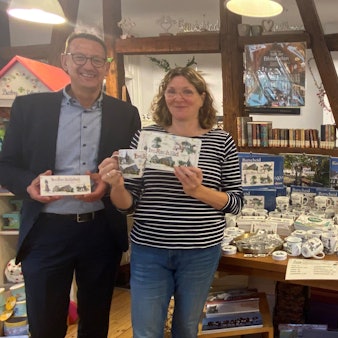 In der Bücherein von Ute Hentschel, hier mit Bürgermeister Dirk Runge, gibt es Tassen, Brettchen und mehr mit Burscheider Motiven darauf.