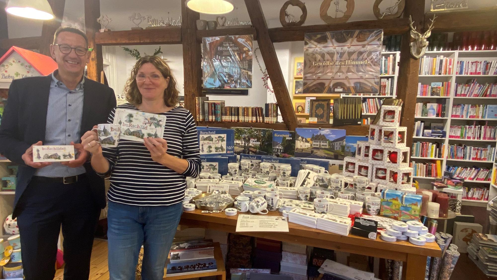 In der Bücherein von Ute Hentschel, hier mit Bürgermeister Dirk Runge, gibt es Tassen, Brettchen und mehr mit Burscheider Motiven darauf.