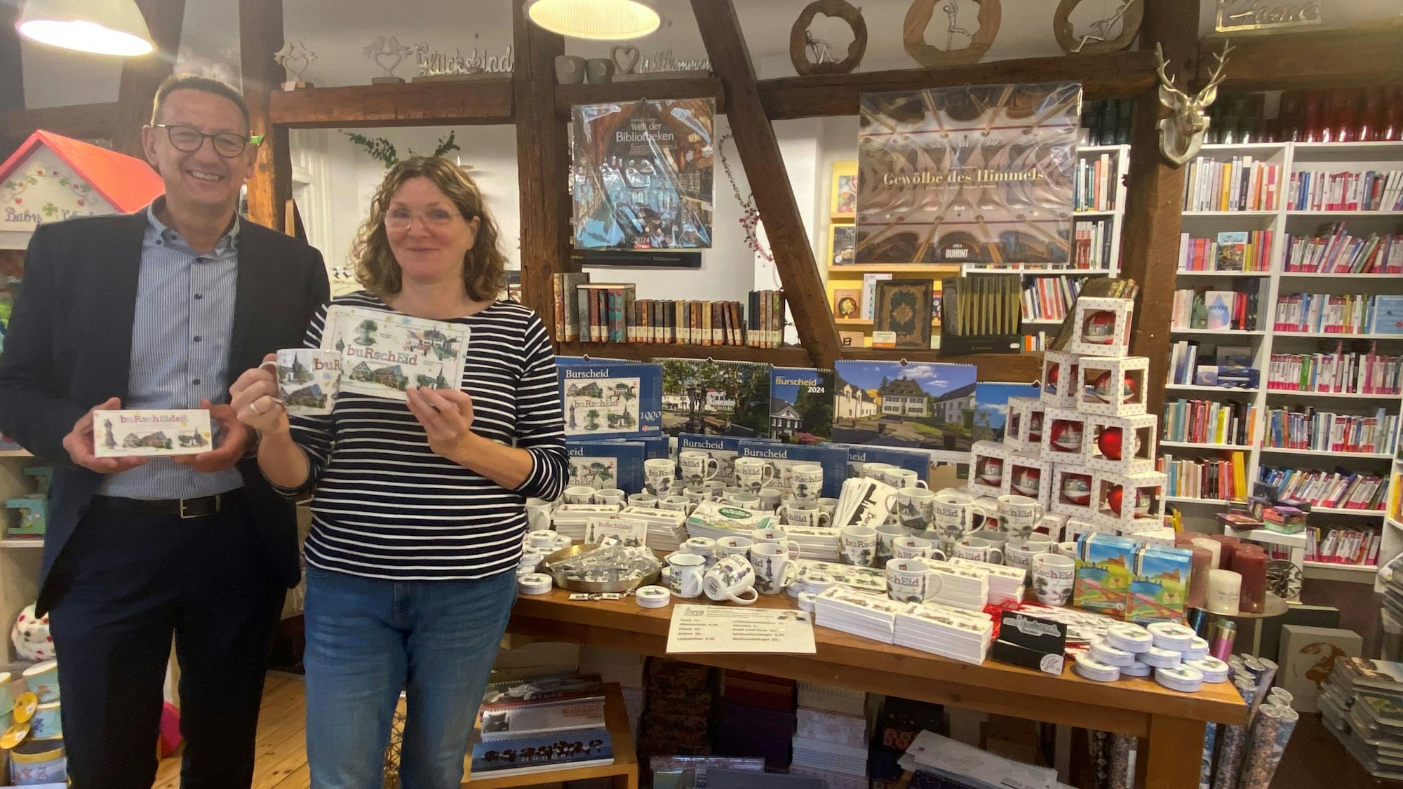 In der Bücherein von Ute Hentschel, hier mit Bürgermeister Dirk Runge, gibt es Tassen, Brettchen und mehr mit Burscheider Motiven darauf.