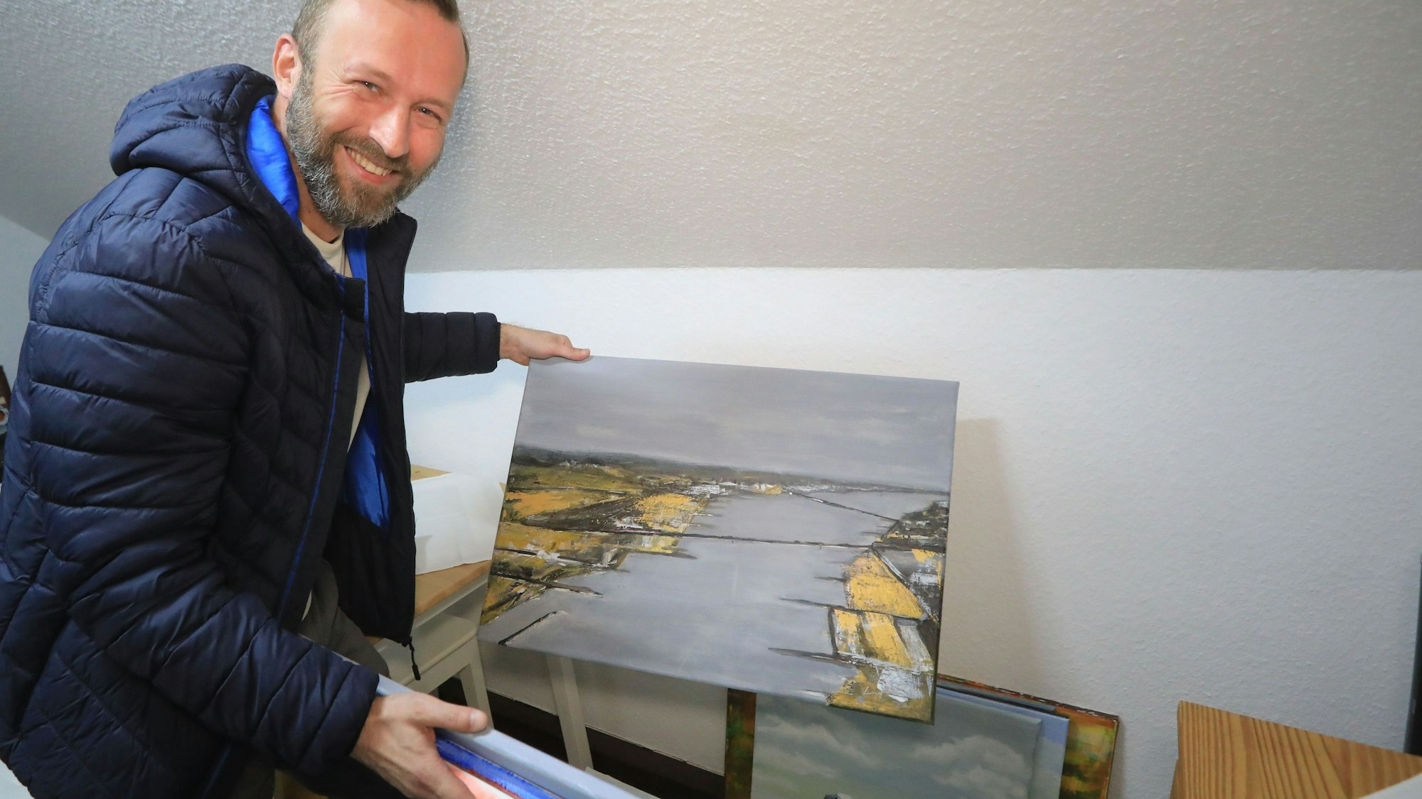 Marek Lissy hält Bilder in die Höhe.