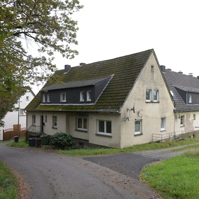 Ein größeres Gebäude umgeben von Wiesen beherbergt in Overath Flüchtlinge. Das Übergangsheim muss saniert werden.